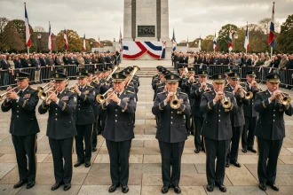 Fanfare militaire en uniforme jouant lors d'une cérémonie commémorative devant un monument aux morts