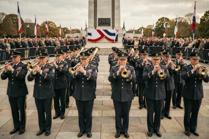Fanfare militaire en uniforme jouant lors d'une cérémonie commémorative devant un monument aux morts